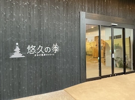 A building with a dark wooden facade and a glass entrance.