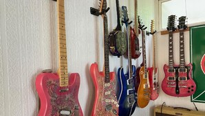 A collection of electric guitars hanging on a wall.