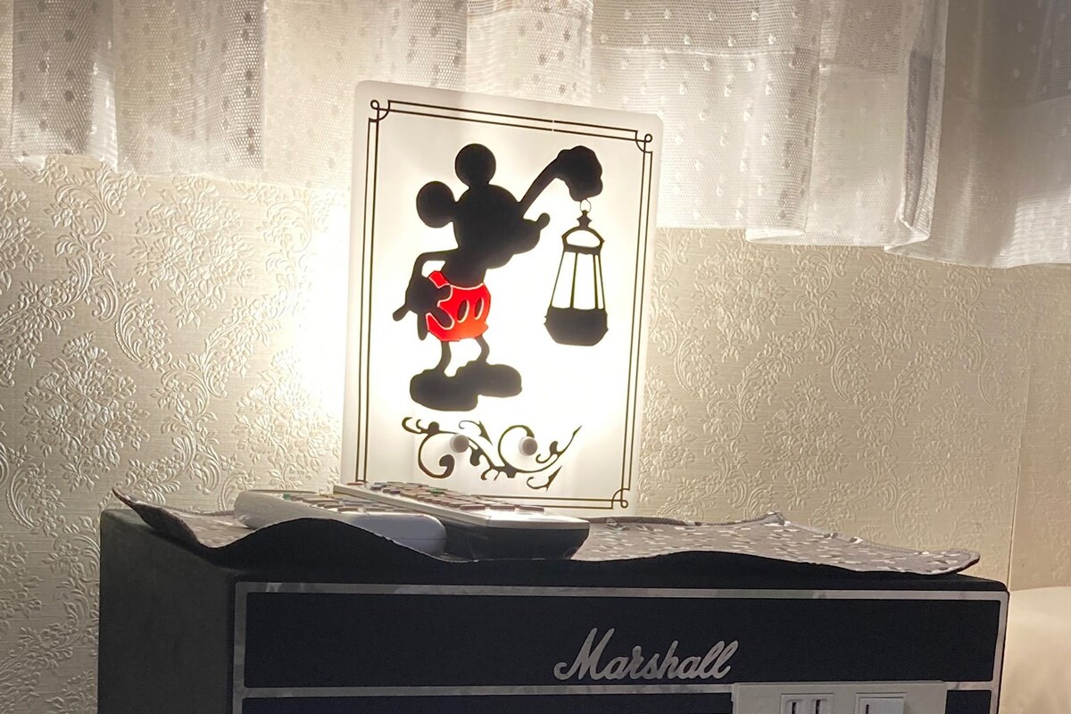 Un sistema de audio Marshall con un adorno silueta de Mickey Mouse, un cubo estampado de lunares y una pared con diseño.