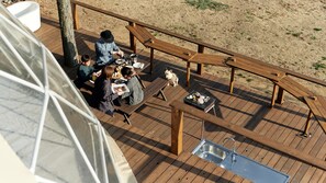 A wooden deck with a metal sink, picnic tables, and a dog. - Glamping Resort Kobe Rokukiku +one (Kobe)