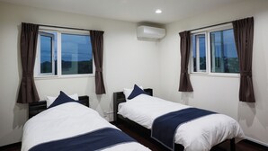 A hotel room with two beds, a window, an air conditioning unit, and curtains. - Code Rooms Okinawa (Nakijin)