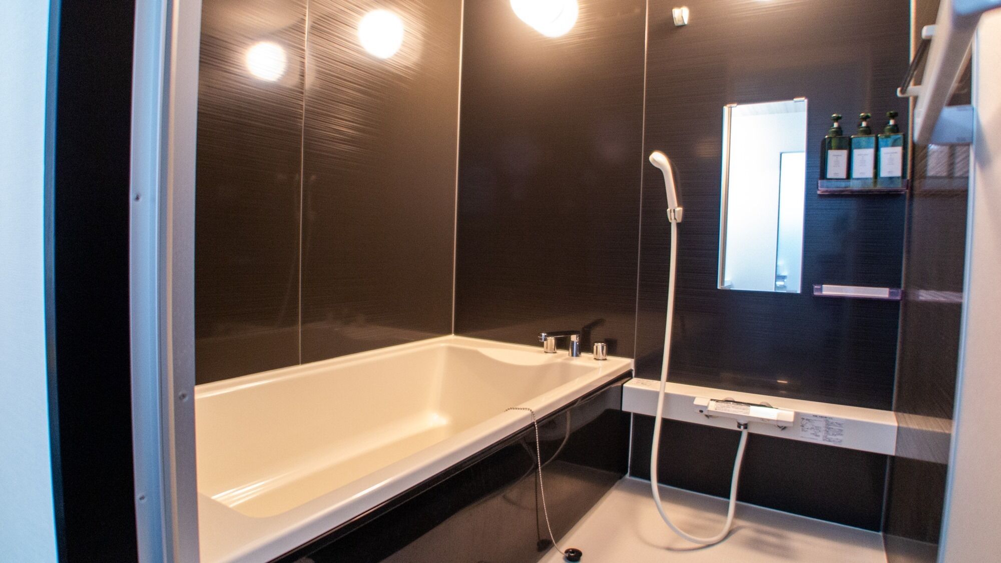 A modern bathroom with a bathtub, a shower, and a mirror.