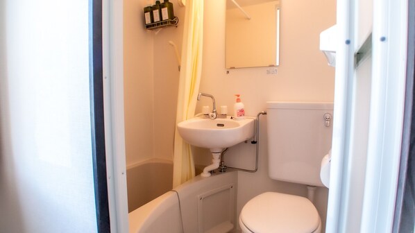 A small bathroom with a white sink, toilet, and bathtub.