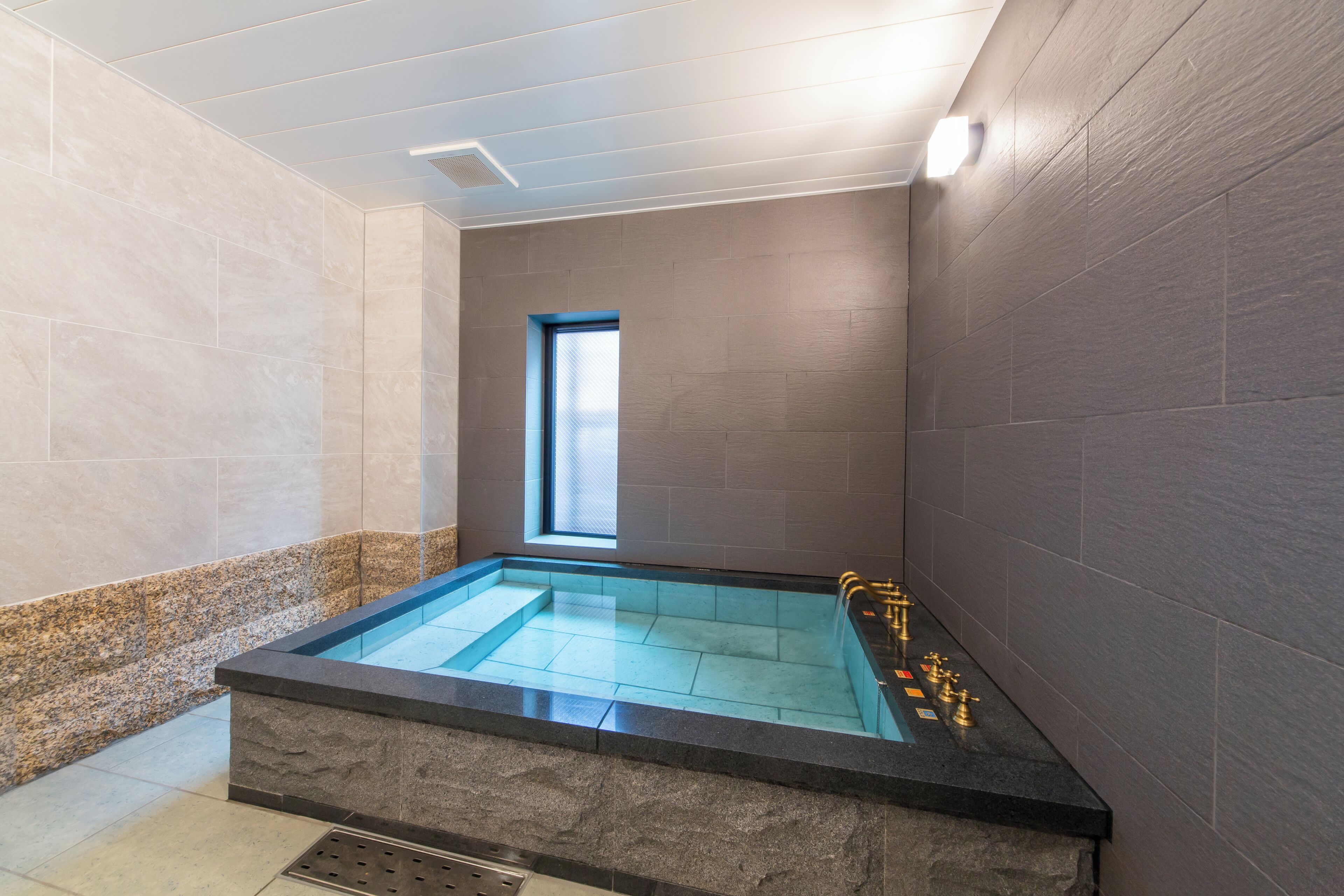 Een moderne badkamer met een rechthoekig whirlpoolbad, een raam en een douche.