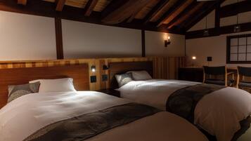 A hotel room with two beds, wooden beams, a nightstand, and a chair.