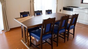 Taula de dinar amb sis cadires, zona de cuina amb rentaplats i terres de fusta.
