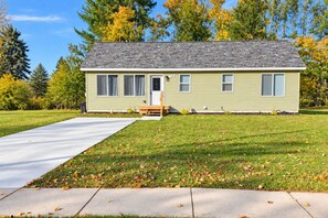 A single-story house with a front porch, a driveway, and a lawn. - New Build Home near Treetops Golf, Lakes & Trails (Gaylord)
