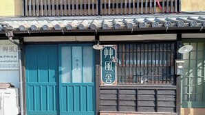 Un edificio tradicional con una puerta azul, un letrero con caracteres chinos y una antena parabólica.