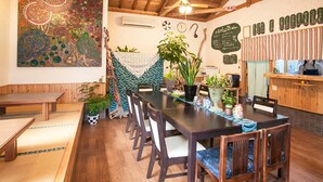 A dining area with a long table, chairs, and potted plants. - Yutorisuto Park Otoyo (Otoyo)