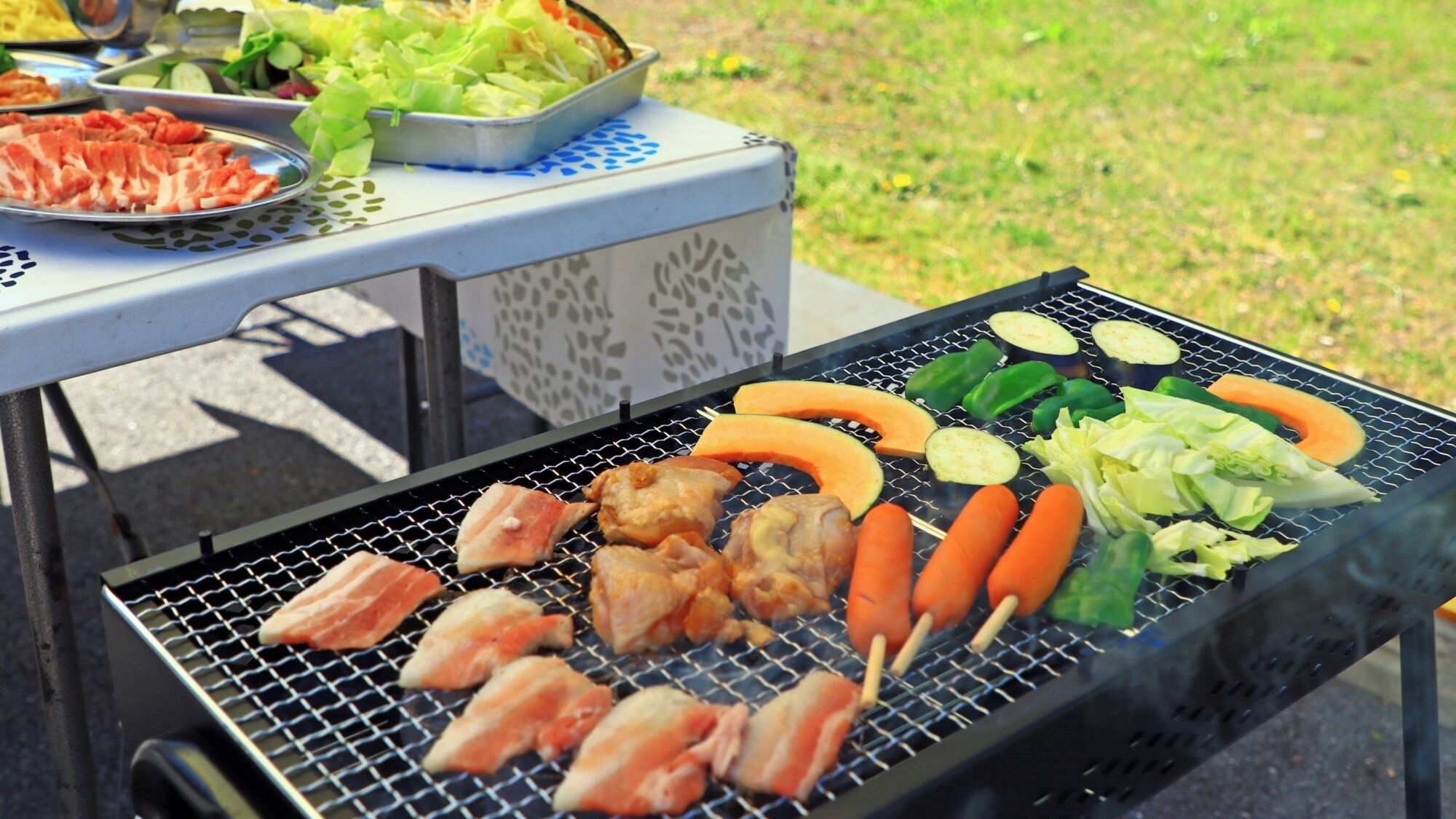 Een barbecue met verschillende vleessoorten en groenten.