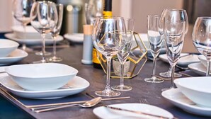 A dining table set with multiple wine glasses, bowls, and a bottle of champagne. - *Sleeps 6* 4 Bedroom House + DriveContractors (Birmingham)