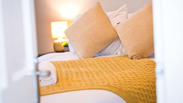 A hotel room with a bed, pillows, and a blanket. - *Sleeps 6* 4 Bedroom House + DriveContractors (Birmingham)