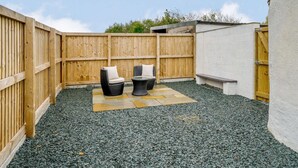 An outdoor patio area with two wicker chairs, a small table, and a wooden fence. - 2 Bed in Cockermouth (oc-85680) (Blindcrake)