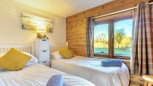 A bedroom with two beds, a radiator, a cabinet, and a window with curtains. - 2 Bed in Honiton (oc-85816) (Sheldon)