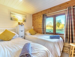 A bedroom with two beds, a radiator, a cabinet, and a window with curtains. - 2 Bed in Honiton (oc-85816) (Sheldon)