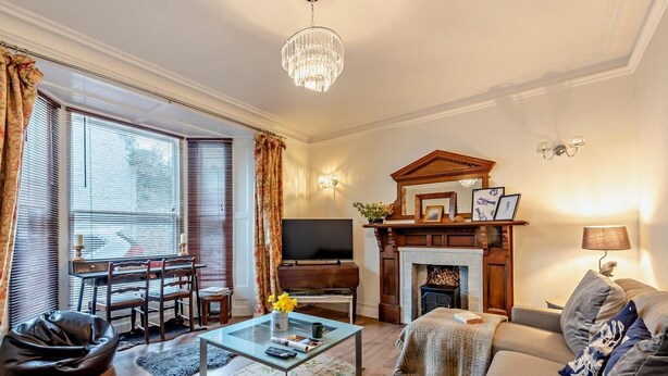 Una sala de estar con chimenea, sofá, mesa de centro y televisor.