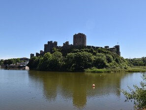 Eine Burg auf einem Hügel mit Blick auf einen ruhigen Fluss.
