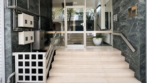 A modern interior with a marble staircase, a glass door entrance, and a number '54' sign. - Acropolis Panorama 2BRM Apartment by MΡS (Athina)