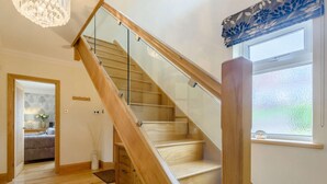 A staircase with glass railings, wooden steps, and a window with a view. - 3 Bed in Colwyn Bay (oc-85763) (Hen Golwyn)