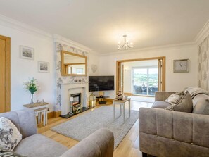 A living room with a fireplace, a television, and a sofa. - 3 Bed in Colwyn Bay (oc-85763) (Hen Golwyn)