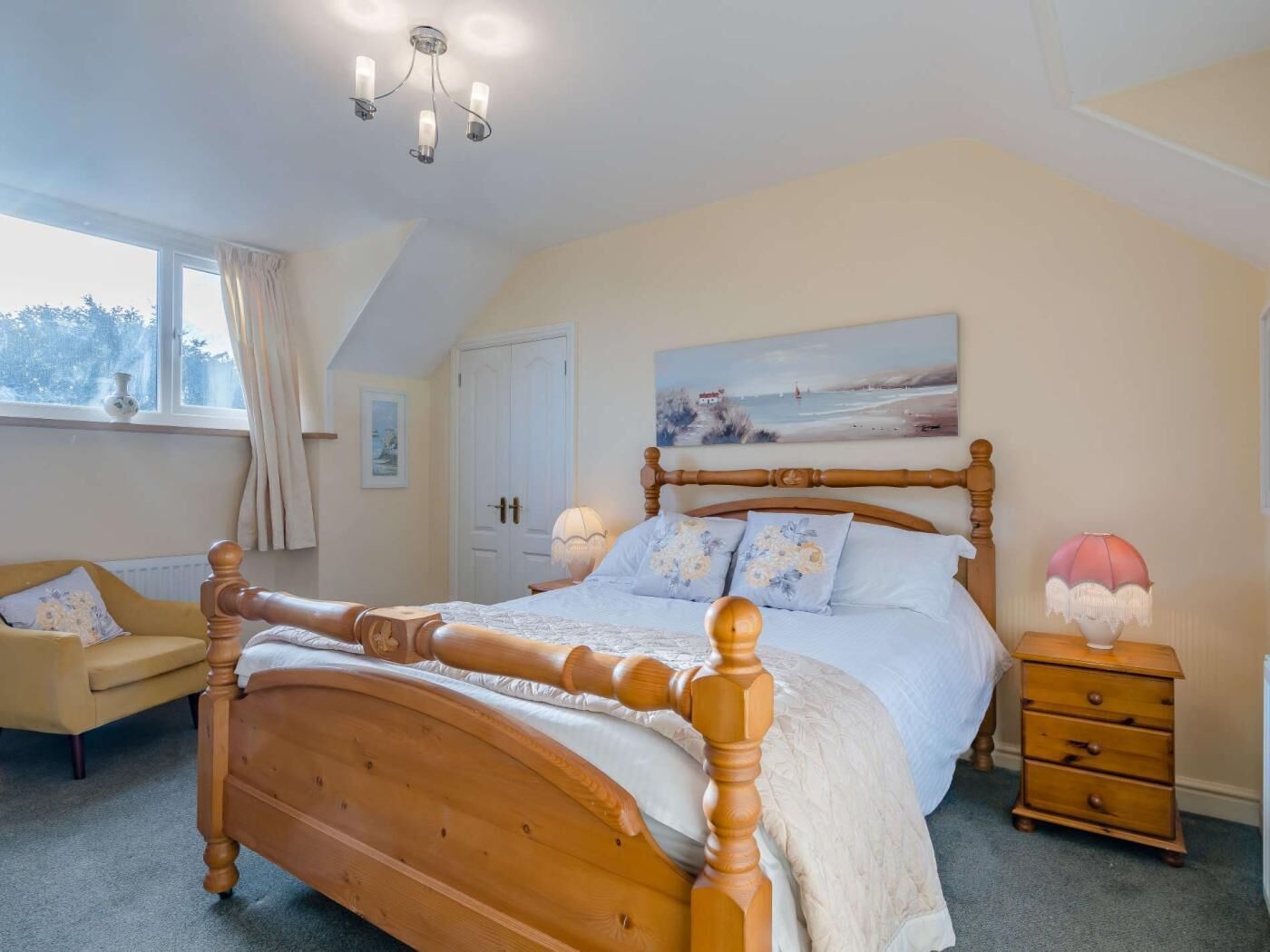 A bedroom with a wooden bed, a nightstand, a dresser, a window with curtains, and a painting on the wall.