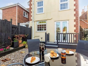 A glass table with a breakfast setup including croissants, a coffee mug, and a jar of jam. - 2 Bed in Great Yarmouth (oc-85872) (Winterton-on-Sea)