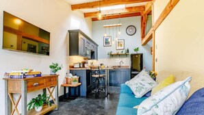 A compact living space with a kitchenette, a dining area, and a sofa with floral cushions. - 1 Bed in Ripon (oc-85511) (Masham)