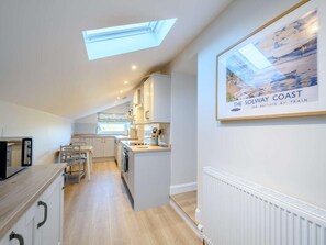 A modern kitchen with a skylight, a dining area, and a framed picture of the Solway Coast. - 1 Bed in Lockerbie (oc-86068) (Lockerbie)