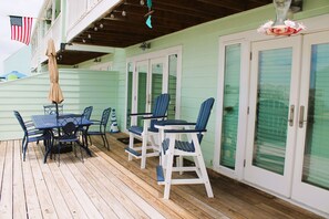 A covered outdoor area with a table and chairs, a flag, and a door with a glass panel. - Fantastic view from Key Allegro in Rockport (Rockport)