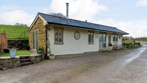 Un petit bâtiment en pierre, doté d’un toit en pente, d’une cheminée et d’une horloge fixée au mur.