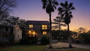 A two-story house with a front porch, a driveway, and a well-maintained lawn. - Wight Tide Landing (Midway)