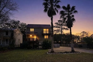 A two-story house with a front porch, a driveway, and a well-maintained lawn. - Wight Tide Landing (Midway)