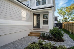 A modern house with a front porch, a small garden, and a wooden fence. - Close to Vilano Beach - Private Hot Tub (St. Augustine)