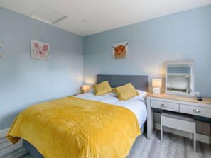 Un dormitorio con cama, mesitas de noche, un espejo y obras de arte en las paredes.