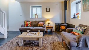 A cozy living room with a fireplace, a sofa, a coffee table, and a rug. - 2 Bed in Clynderwen (oc-86158) (Clynderwen)
