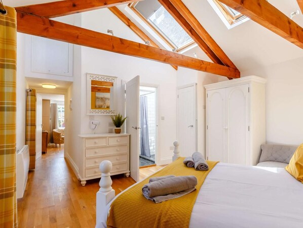 A bedroom with a skylight, a bed with a yellow blanket, a white dresser, and a wardrobe. - 1 Bed in Penzance (oc-86149) (Saint Hilary)