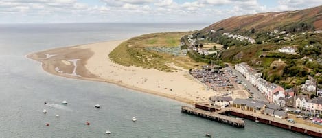 Un pueblo costero con playa, muelle y edificios residenciales.