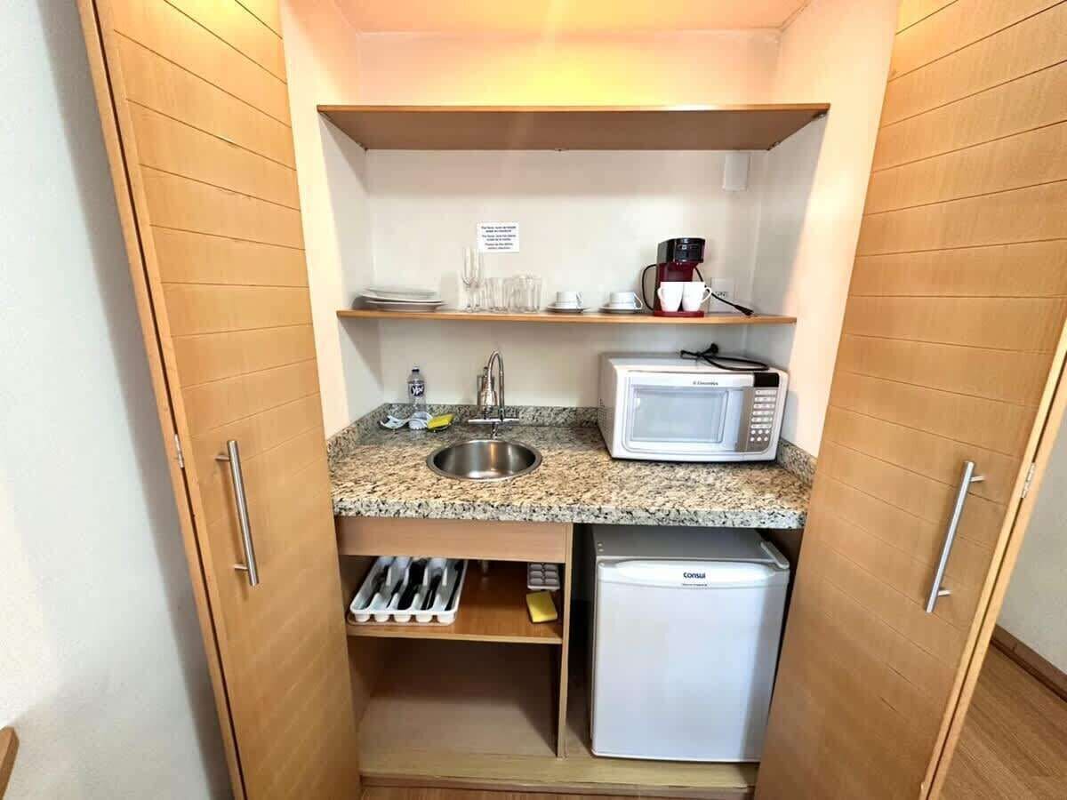 A compact kitchenette with a microwave, coffee maker, and a small refrigerator.