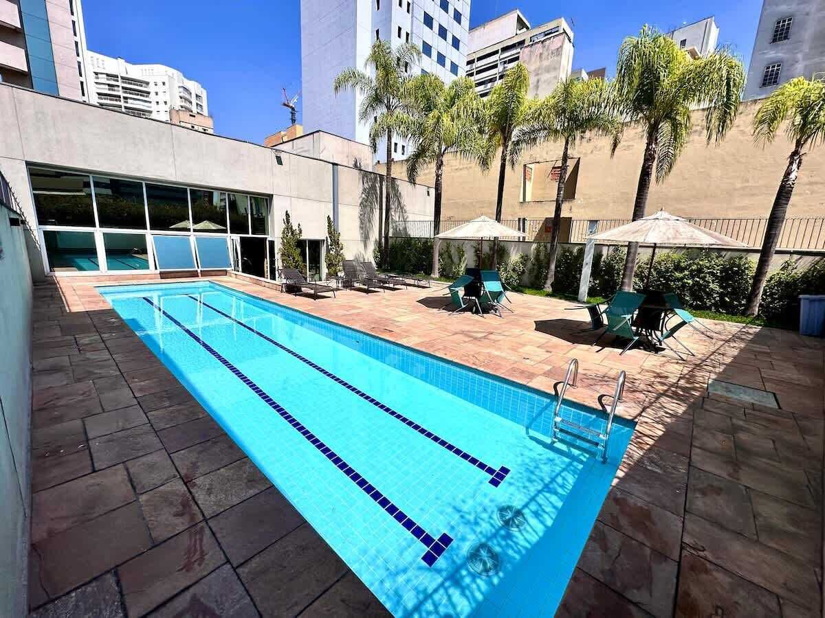 A rectangular swimming pool with clear blue water, surrounded by a tiled deck.