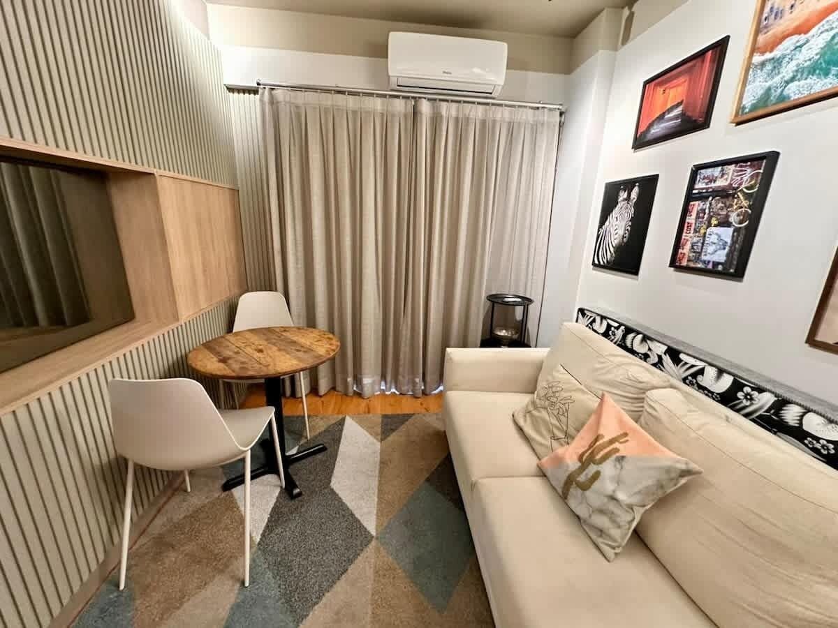Un espacio habitable compacto con sofá, una mesa redonda y una silla.