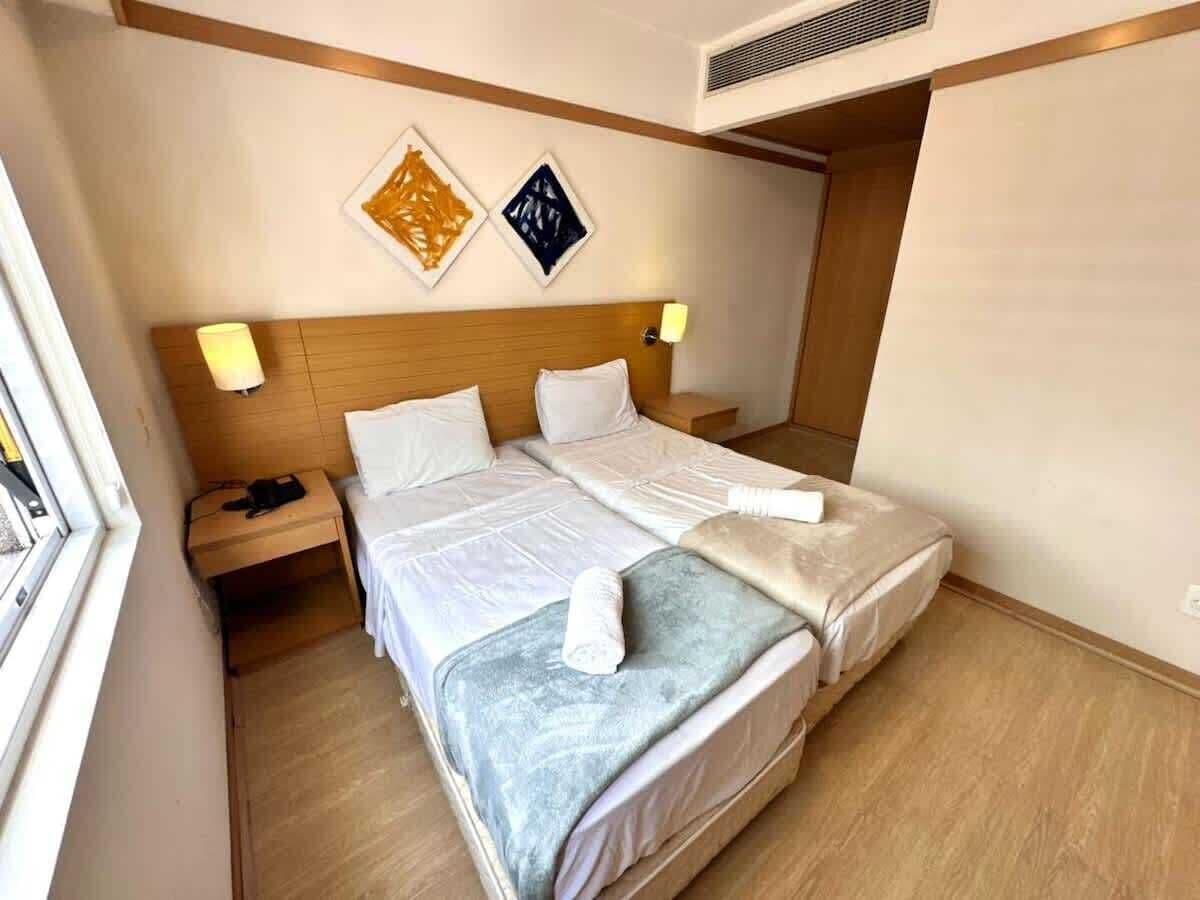 Una habitación de hotel con cama, mesitas de noche y decoración en la pared.