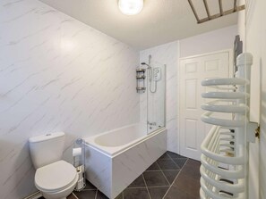 Ein Badezimmer mit Toilette, Badewanne und Dusche.