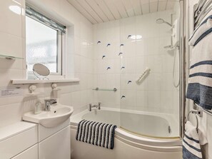 A bathroom with a sink, mirror, and bathtub. - 2 Bed in Chathill (oc-86877) (Beadnell)
