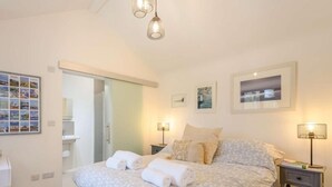 A bedroom with a bed, bedside tables, a wardrobe, and a bathroom visible through an open door. - 1 Bed in Wareham (oc-87150) (Ridge)