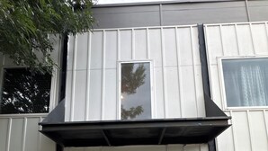 A building with a white facade, a black awning, and a door marked with the number 1515. - Modern Luxe Escape with Spa Shower, Digital Fireplace & Prime Location (Dallas)