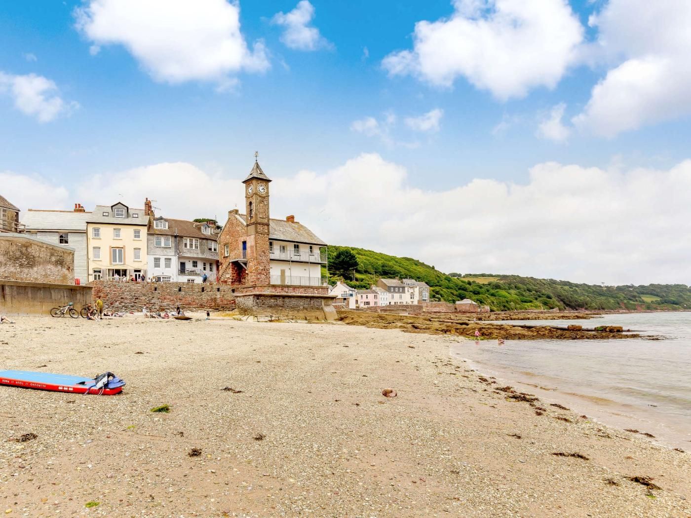 Une ville côtière dotée d’un imposant beffroi, d’une plage de sable et de bâtiments qui bordent la côte.