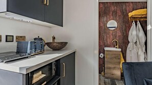 A modern kitchen with a built-in oven, a bowl, and a coffee maker.