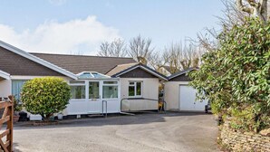 A residential property with a garage, a covered patio, and a gravel driveway. - 2 Bed in Bude (oc-87225) (Kilkhampton)