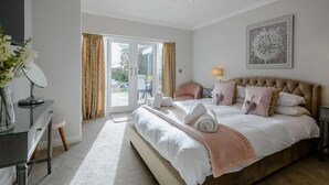 Une chambre à coucher avec un lit, un bureau, une chaise, une lampe et un tableau au mur.