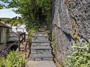A stone staircase leading up a hill, surrounded by greenery and a stone wall. - 2 Bed in Aberdyfi (oc-dy011) (Aberdovey)